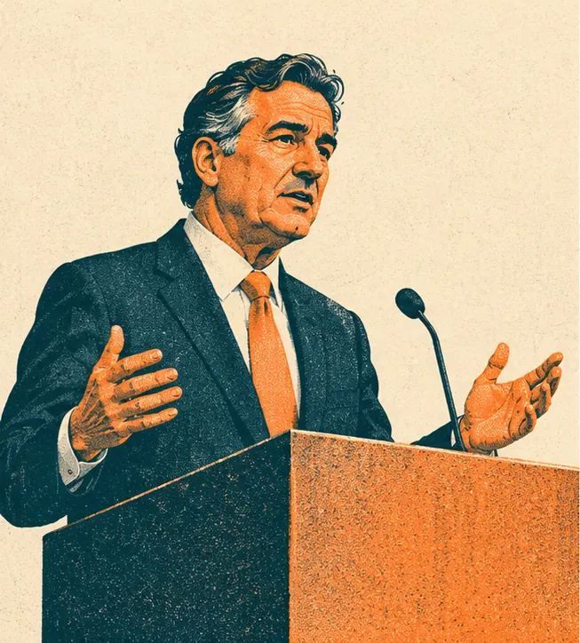 An anonymous dark-haired man in his fifties speaking at a plain podium in front of a blank backdrop